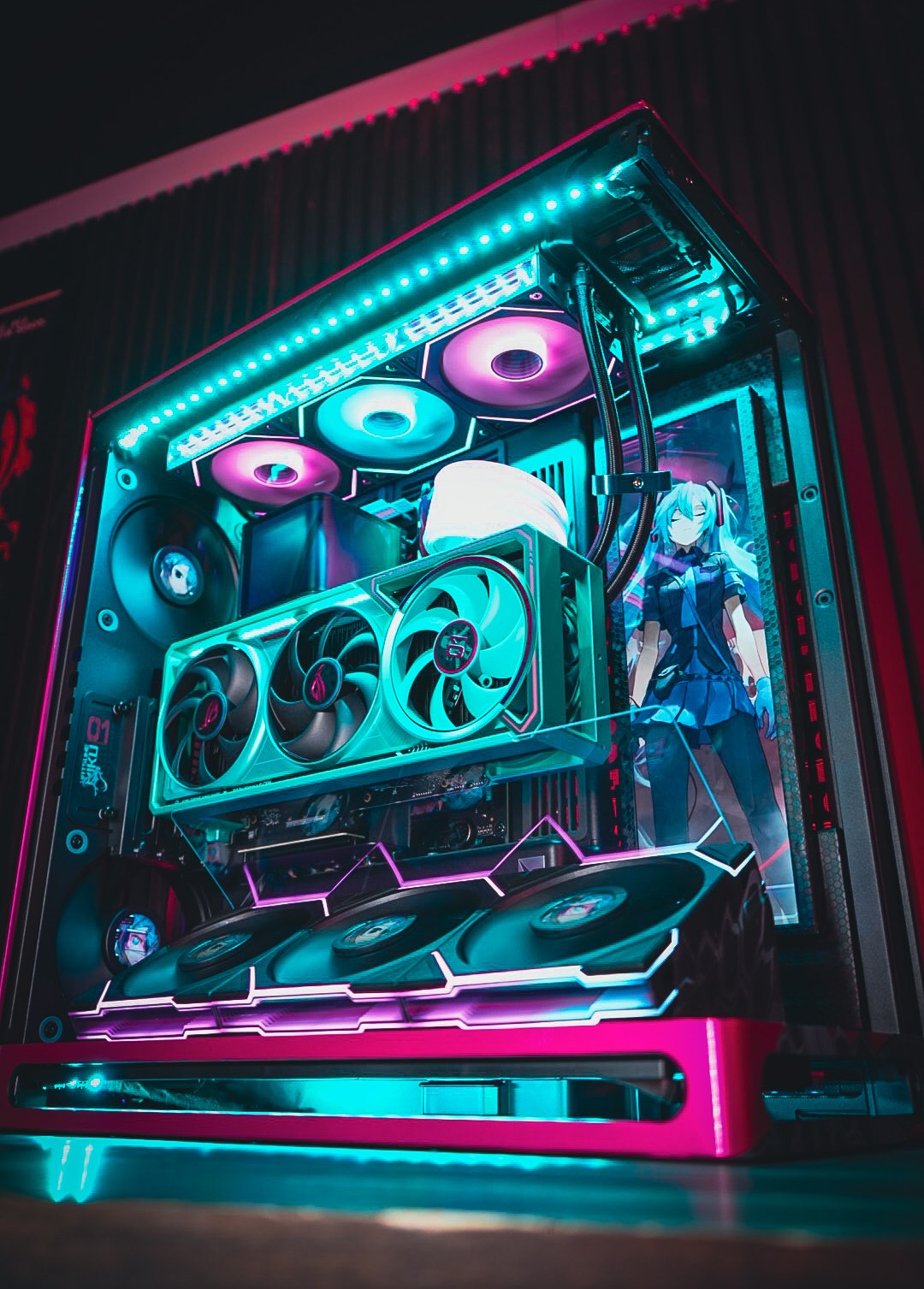 A custom gaming PC with cyan and pink RGB lighting